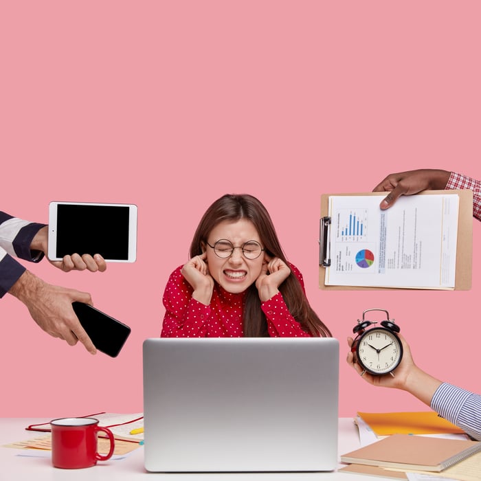 brunette-woman-sitting-desk-surrounded-with-gadgets-papers